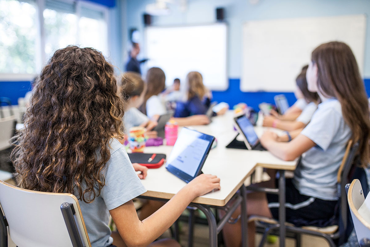 children in classroom using tablets